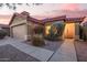 Charming single-story home with desert landscaping, featuring a 2-car garage and a welcoming front entrance under a pink sky at 8132 E Onza Ave, Mesa, AZ 85212