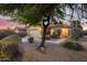 Charming single-story home with desert landscaping, featuring a 2-car garage and a welcoming front entrance under a pink sky at 8132 E Onza Ave, Mesa, AZ 85212