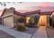Charming single-story home with desert landscaping, featuring a 2-car garage and a welcoming front entrance under a pink sky at 8132 E Onza Ave, Mesa, AZ 85212