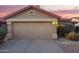 Home exterior showcasing a 2-car garage with a charming desert landscape and a red tile roof under a colorful evening sky at 8132 E Onza Ave, Mesa, AZ 85212