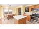 Bright kitchen with a tile floor, a breakfast nook, an island, an oven, and wooden cabinets at 8132 E Onza Ave, Mesa, AZ 85212
