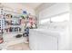 Bright laundry area featuring a side-by-side washer and dryer set and convenient built-in shelving at 8132 E Onza Ave, Mesa, AZ 85212