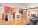 Bright living room with hardwood floors, a cozy fireplace, and open dining area at 8132 E Onza Ave, Mesa, AZ 85212