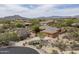 Aerial view of a desert home surrounded by lush greenery, a circular driveway, and mountain views at 8698 E Preserve Way, Scottsdale, AZ 85266
