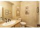 Half-bathroom is decorated with western art, textured walls, and a white sink and toilet at 8698 E Preserve Way, Scottsdale, AZ 85266