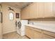 Bright laundry room with tile floor, large capacity washer and dryer, and plenty of storage cabinets at 8698 E Preserve Way, Scottsdale, AZ 85266