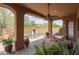 Outdoor patio with dining area, ceiling fan, arched openings, and views of the backyard swimming pool at 8698 E Preserve Way, Scottsdale, AZ 85266