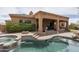 Backyard pool with a waterfall feature, stone pavers, lush landscaping, and an outdoor fire pit at 8698 E Preserve Way, Scottsdale, AZ 85266