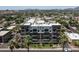 An aerial view shows the condo building among lush landscape, city buildings, and distant mountains at 914 E Osborn Rd # 404, Phoenix, AZ 85014