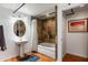 Cozy bathroom with a pedestal sink, bathtub, and unique tile accent wall with a decorative shower curtain at 914 E Osborn Rd # 404, Phoenix, AZ 85014