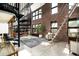 Charming living room with exposed brick, spiral staircase, and large windows bringing in natural light at 914 E Osborn Rd # 404, Phoenix, AZ 85014