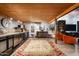 Spacious living room with stylish wet bar, wood ceiling, and elegant rug at 914 E Osborn Rd # 404, Phoenix, AZ 85014