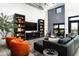 Bright living room with high ceilings, a black leather sofa, and eye-catching orange chairs at 914 E Osborn Rd # 404, Phoenix, AZ 85014