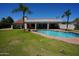 Spacious backyard with pool, mature trees, and a large grass area at 9505 E Jenan Dr, Scottsdale, AZ 85260