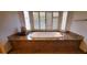 Bathroom with a soaking tub surrounded by granite at 9505 E Jenan Dr, Scottsdale, AZ 85260