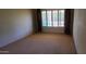 Bedroom features plush carpeting and a large window with light-filtering shutters at 9505 E Jenan Dr, Scottsdale, AZ 85260