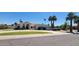 Inviting single-story home with lush green lawn, desert landscaping, and a circular driveway at 9505 E Jenan Dr, Scottsdale, AZ 85260