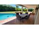Covered patio with a spacious table and chairs adjacent to the sparkling pool at 9505 E Jenan Dr, Scottsdale, AZ 85260