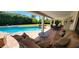 A luxurious cushioned outdoor sofa sits on a covered patio next to the pool and lush backyard at 9505 E Jenan Dr, Scottsdale, AZ 85260