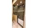 Bathroom shower featuring glass door and dark tiled walls with decorative band at 9505 E Jenan Dr, Scottsdale, AZ 85260
