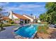 Expansive backyard with sparkling pool, patio, and lush landscaping, perfect for outdoor entertaining and relaxation at 9821 E Windrose Dr, Scottsdale, AZ 85260