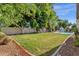 Expansive backyard featuring lush lawn, mature trees, and convenient access to pool area for outdoor enjoyment at 9821 E Windrose Dr, Scottsdale, AZ 85260