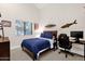 Bedroom with surf decor, plush bed, and an adaptable workspace setup at 9821 E Windrose Dr, Scottsdale, AZ 85260