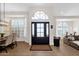 Inviting entryway with a black front door, transom window, and view into the dining and living room at 9821 E Windrose Dr, Scottsdale, AZ 85260