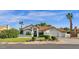 Beautiful single-story home with a tile roof, manicured lawn, mature trees, and a three-car garage at 9821 E Windrose Dr, Scottsdale, AZ 85260