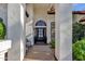 Covered entryway features an arched window, a bench, and plants, creating an inviting and charming entrance at 9821 E Windrose Dr, Scottsdale, AZ 85260
