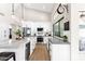 Modern white kitchen with stainless steel appliances, marble island, and ample counter space at 9821 E Windrose Dr, Scottsdale, AZ 85260