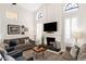 Bright living room with a stone fireplace, vaulted ceilings, and modern decor, creating a cozy atmosphere at 9821 E Windrose Dr, Scottsdale, AZ 85260