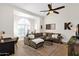Open living room with large sectional sofa, ceiling fan, and expansive arched window with shutters at 9821 E Windrose Dr, Scottsdale, AZ 85260