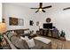 Cozy living room features a sectional sofa, ceiling fan, and entertainment center with decorative accents at 9821 E Windrose Dr, Scottsdale, AZ 85260