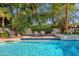 Serene pool area with cozy seating, lush greenery, and tranquil atmosphere creates a perfect backyard retreat at 9821 E Windrose Dr, Scottsdale, AZ 85260