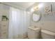 Bright bathroom with floral shower curtain, patterned wall, and an oval mirror above the vanity at 1003 E Mariposa St, Phoenix, AZ 85014