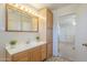 Well-lit bathroom featuring a sink with mirror, linoleum floors, and direct access to a bedroom at 1003 E Mariposa St, Phoenix, AZ 85014