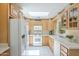 Well-lit kitchen featuring a skylight, white appliances, light wood cabinets, and a tile backsplash at 1003 E Mariposa St, Phoenix, AZ 85014