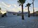 Backyard view of stucco home featuring gravel yard, palms, and a modern exterior at 10637 N 16Th Ave, Phoenix, AZ 85029