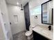 Modern bathroom with glass shower, rock floor, modern vanity and large mirror at 10637 N 16Th Ave, Phoenix, AZ 85029