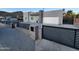 Contemporary home featuring a gray stucco exterior, gravel landscaping, black metal fence, and an attached two-car garage at 10637 N 16Th Ave, Phoenix, AZ 85029
