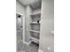 View of shelving in hallway with gray walls, light trim, and gray tile flooring at 10637 N 16Th Ave, Phoenix, AZ 85029