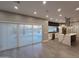 Modern kitchen with stainless steel appliances, gray floors, white cabinetry, island cooktop, and sliding doors to the backyard at 10637 N 16Th Ave, Phoenix, AZ 85029