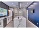 Modern kitchen features a spacious island with quartz countertop, stainless steel appliances and a blue accent wall at 10637 N 16Th Ave, Phoenix, AZ 85029