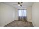 Spare bedroom with a ceiling fan, carpeted floor, and a window with sheer curtains at 1107 E La Salle St, Phoenix, AZ 85040