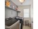 Functional laundry room is equipped with modern washer and dryer and ample shelving at 1107 E La Salle St, Phoenix, AZ 85040