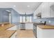 Open kitchen features white cabinetry, a stainless steel dishwasher, and a gas range at 11630 W Jefferson St, Avondale, AZ 85323