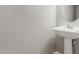 Bathroom featuring a pedestal sink and oval mirror creating a minimalist and stylish design at 13617 W Crocus Dr, Surprise, AZ 85379