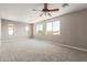 Spacious bedroom with neutral carpet, paint, ceiling fan and multiple windows providing ample natural light at 13617 W Crocus Dr, Surprise, AZ 85379