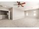 Large bedroom features plush carpet, neutral paint, ceiling fan and doorway to living space at 13617 W Crocus Dr, Surprise, AZ 85379